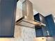 Sleek kitchen featuring custom blue cabinets, a stainless steel range hood, and elegant hexagonal marble backsplash at 1320 Stanley Park Dr # 141, Decatur, GA 30033