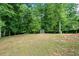 Large backyard with lawn and mature trees, plus a storage shed for outdoor equipment at 4205 Mabry Ne Rd, Roswell, GA 30075