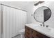 Bathroom features include a vanity, a white tile shower, and a stylish round mirror at 4205 Mabry Ne Rd, Roswell, GA 30075