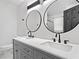 Bathroom featuring double sinks, modern fixtures, round mirrors and a large counter top at 4205 Mabry Ne Rd, Roswell, GA 30075