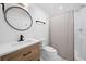 Bathroom featuring a wood vanity, modern fixtures, round mirror, and walk-in shower at 4205 Mabry Ne Rd, Roswell, GA 30075