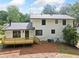 Rear exterior view of home featuring a wooden deck, neutral siding, dark window trim, and mature trees at 4205 Mabry Ne Rd, Roswell, GA 30075