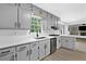 Well-lit kitchen with modern countertops, sleek cabinetry and an adjacent living area at 4205 Mabry Ne Rd, Roswell, GA 30075