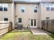 Townhome's backyard with wood privacy fence, small patio, green lawn, and rear building exterior at 4922 Longview Walk, Decatur, GA 30035