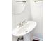 Bright bathroom featuring a stylish pedestal sink with chrome fixtures and a modern round mirror at 4922 Longview Walk, Decatur, GA 30035