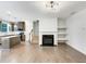 Open-concept living room featuring a sleek fireplace, floating shelves, and a view into the kitchen area at 4922 Longview Walk, Decatur, GA 30035