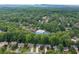 Aerial view of a neighborhood featuring mature trees, manicured lawns, and community amenities amid a lush, green landscape at 4957 Day Lily Nw Way, Acworth, GA 30102