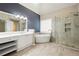 Beautiful bathroom featuring a soaking tub, glass-enclosed shower, double vanity, and wood-look tile flooring at 4957 Day Lily Nw Way, Acworth, GA 30102