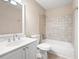 Bathroom featuring single sink vanity, large mirror, and tiled shower and tub combo at 4957 Day Lily Nw Way, Acworth, GA 30102