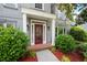 Close up of the front door, with lush landscaping, mulched beds, and a brick walkway at 4957 Day Lily Nw Way, Acworth, GA 30102