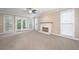 Spacious living room with neutral carpet, fan, fireplace, and access to a patio at 4957 Day Lily Nw Way, Acworth, GA 30102