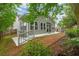 Backyard view of home with patio, stairs, outdoor kitchen, and partial fence surrounded by lush landscaping at 613 Wiley Ct, Canton, GA 30115
