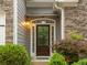 Close-up of the home's front door with stone accents, tasteful landscaping, and exterior lighting at 613 Wiley Ct, Canton, GA 30115