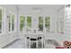 Inviting sunroom features a dining table set near multiple windows, offering serene backyard views and ample natural light at 613 Wiley Ct, Canton, GA 30115