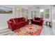 Comfortable sunroom featuring red sofas, large windows providing natural light, and a patterned rug on sleek gray flooring at 613 Wiley Ct, Canton, GA 30115