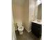 Powder room featuring a toilet and vanity with black cabinet and oval mirror at 143 Ilex Dr, Canton, GA 30114