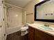Full bathroom showcasing a bathtub, toilet and vanity with a dark framed mirror at 143 Ilex Dr, Canton, GA 30114