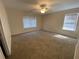 Bright bedroom with plush carpeting, ceiling fan and natural light from the two windows at 143 Ilex Dr, Canton, GA 30114
