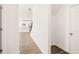 A view from the hallway into the bright, white kitchen with stainless steel appliances and hardwood floors at 1851 Lacebark Elm Way, Lawrenceville, GA 30045