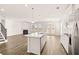 Modern open concept kitchen featuring stainless steel appliances, large island with bar seating, and ample natural light at 1851 Lacebark Elm Way, Lawrenceville, GA 30045