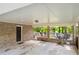 A covered back porch with brick columns, concrete floor, and an outdoor seating area at 4379 Bonaparte Dr, Tucker, GA 30084