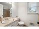 Well lit bathroom with a wide window, pedestal sink and tiled shower at 4379 Bonaparte Dr, Tucker, GA 30084