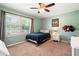 Bright bedroom featuring a ceiling fan, carpeted floors, green walls, and a sunny window at 4379 Bonaparte Dr, Tucker, GA 30084