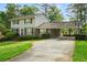 A two-story home with a well-kept lawn and a covered carport featuring a basketball hoop at 4379 Bonaparte Dr, Tucker, GA 30084