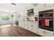 Well-lit kitchen featuring white cabinets, stainless steel appliances, hardwood floors and backyard views at 4379 Bonaparte Dr, Tucker, GA 30084