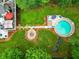 Aerial view of a home with a pool, firepit, and lush backyard with trees at 827 Pinehurst Dr, Woodstock, GA 30188