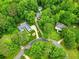 Aerial shot showing the property's placement in a lush, green neighborhood with multiple homes, circular drive, and pool at 827 Pinehurst Dr, Woodstock, GA 30188