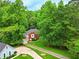 Aerial view of a brick home with a long driveway surrounded by lush greenery and mature trees at 827 Pinehurst Dr, Woodstock, GA 30188