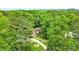 Aerial view of a brick home nestled in a wooded area with a circular driveway at 827 Pinehurst Dr, Woodstock, GA 30188