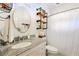 A stylish bathroom featuring a granite countertop sink, industrial shelves, and a shower with white curtain at 827 Pinehurst Dr, Woodstock, GA 30188