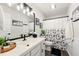Bright bathroom featuring a modern vanity, decorative mirror, and a shower with patterned curtain at 827 Pinehurst Dr, Woodstock, GA 30188