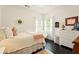 A comfortable bedroom with natural light from large windows, simple décor and wood-look floors at 827 Pinehurst Dr, Woodstock, GA 30188