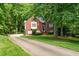 Traditional brick home with a well-manicured front yard, featuring a long driveway and mature trees at 827 Pinehurst Dr, Woodstock, GA 30188