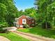 Well-maintained brick home with green lawn and mature trees, creating a serene setting at 827 Pinehurst Dr, Woodstock, GA 30188