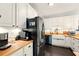 Beautiful kitchen showcasing stainless steel appliances, white cabinetry, butcher block countertops, and modern fixtures at 827 Pinehurst Dr, Woodstock, GA 30188