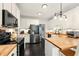 Bright kitchen featuring stainless steel appliances, white cabinets, butcher block countertops, and modern lighting at 827 Pinehurst Dr, Woodstock, GA 30188
