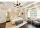 Relaxing main bedroom featuring a tray ceiling, ceiling fan, natural light, and a decorative rug at 827 Pinehurst Dr, Woodstock, GA 30188