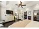 Bright main bedroom featuring a tray ceiling, ceiling fan, dresser with TV, and walk-in closet at 827 Pinehurst Dr, Woodstock, GA 30188