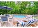 Backyard in-ground pool with surrounding deck, featuring lounge chairs and umbrella, perfect for summer relaxation at 827 Pinehurst Dr, Woodstock, GA 30188