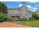 Back exterior with a multi-level deck, stairs, and lush greenery for serene outdoor living at 1663 Willow Way, Woodstock, GA 30188