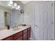 Bathroom featuring a vanity with a white countertop, dark wood cabinets, and a large mirror at 1663 Willow Way, Woodstock, GA 30188