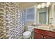 Bathroom showcasing a shower with curtain, commode and sink with vanity cabinet at 1663 Willow Way, Woodstock, GA 30188