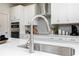 Close-up of a kitchen sink and faucet in a modern kitchen with stainless steel appliances and stylish fixtures at 1781 Jordan Brook Dr, Lawrenceville, GA 30043