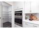 Kitchen featuring a double oven, open pantry, white cabinets, and modern finishes at 1781 Jordan Brook Dr, Lawrenceville, GA 30043