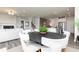 Open-concept living and dining area features a dark wood table and flows into the modern kitchen at 1781 Jordan Brook Dr, Lawrenceville, GA 30043