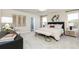 Beautifully staged main bedroom with a large upholstered headboard, bench seat, and ensuite bathroom access at 1781 Jordan Brook Dr, Lawrenceville, GA 30043